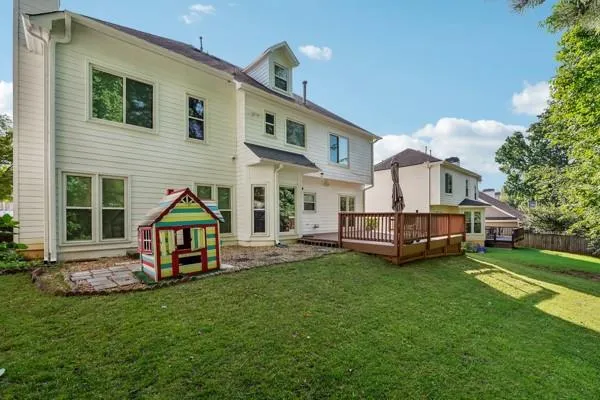 a view of a house with a yard and deck