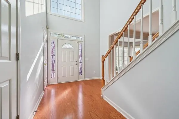 a view of a hallway with wooden floor and staircase