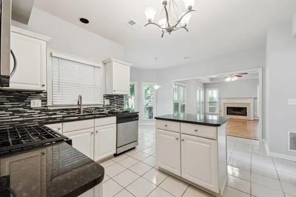 a kitchen with granite countertop white cabinets and white appliances