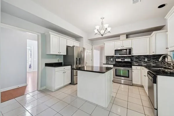 a kitchen with white cabinets and appliances