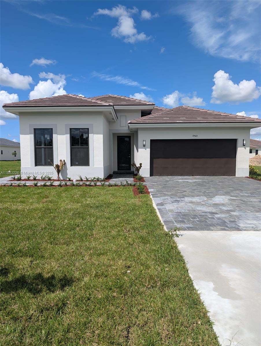 a front view of a house with yard and garage