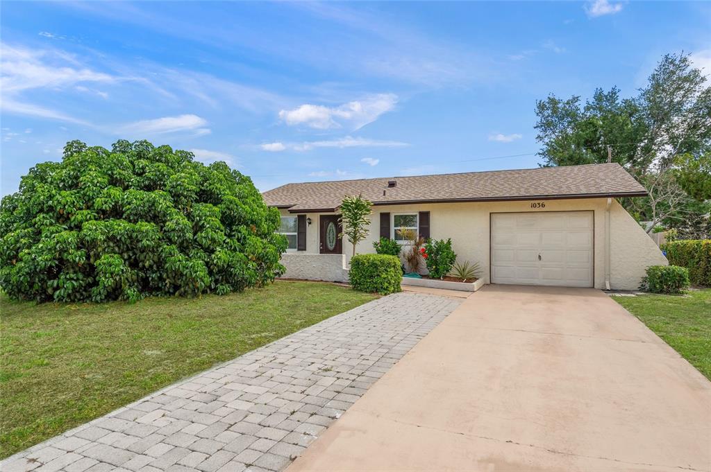 1036 Hope Street Venice, FL 34285 - Photo 1 of 41 a front view of a house with a yard and garage