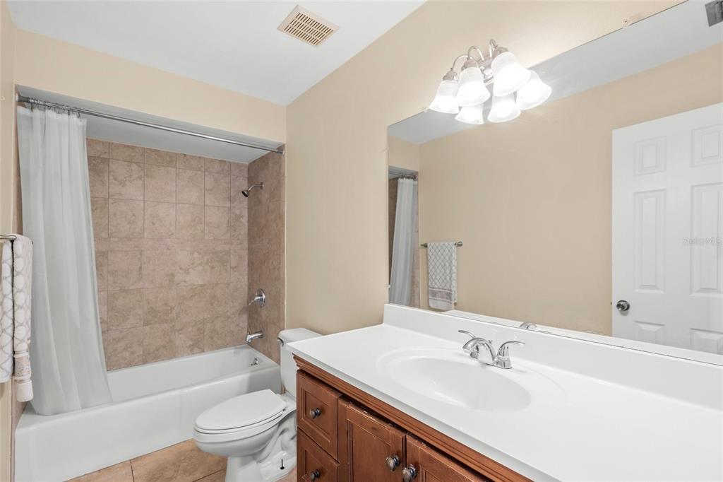 1036 Hope Street Venice, FL 34285 - Photo 15 of 41 a bathroom with a sink a toilet a mirror a bathtub and shower
