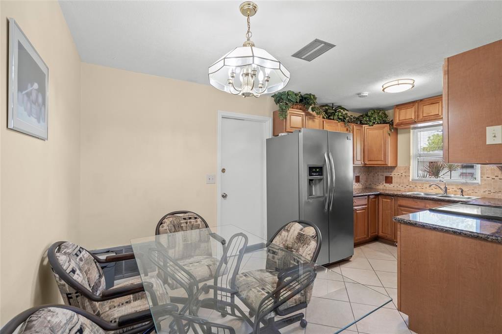 1036 Hope Street Venice, FL 34285 - Photo 7 of 41 a dining room with stainless steel appliances granite countertop furniture and a chandelier
