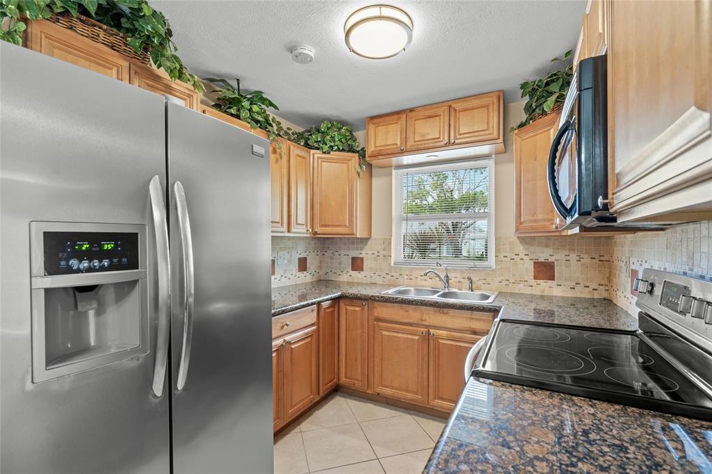1036 Hope Street Venice, FL 34285 - Photo 8 of 41 a kitchen with stainless steel appliances granite countertop a refrigerator sink and stove