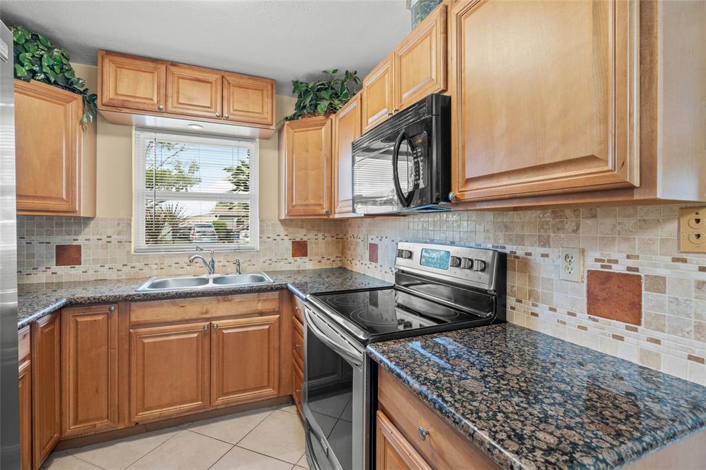 1036 Hope Street Venice, FL 34285 - Photo 9 of 41 a kitchen with stainless steel appliances granite countertop a sink stove and cabinets