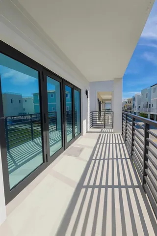 a view of balcony with floor to ceiling window and wooden floor