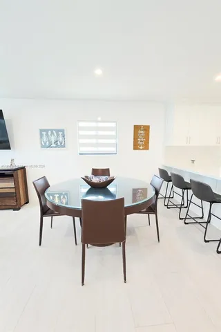 a kitchen with stainless steel appliances a dining table chairs and a refrigerator