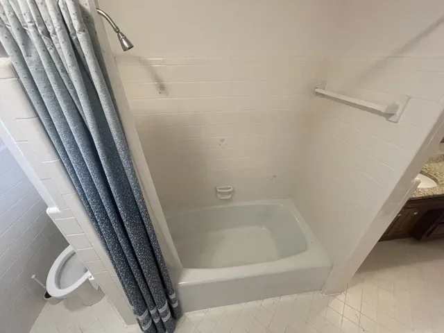 a bathroom with a granite countertop sink a mirror and shower
