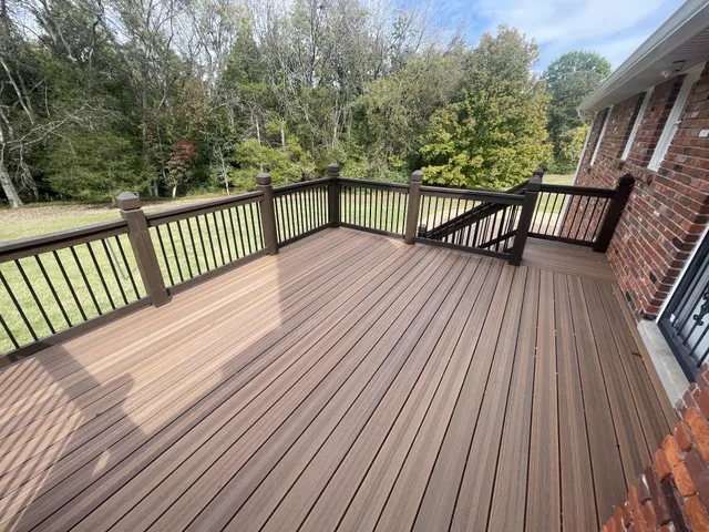 a view of a balcony with wooden floor and fence