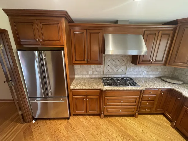 a kitchen with stainless steel appliances granite countertop a refrigerator and a stove