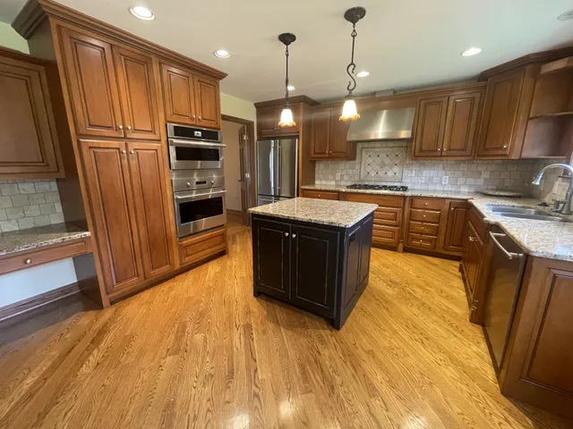 a kitchen with stainless steel appliances granite countertop a sink a stove and a refrigerator