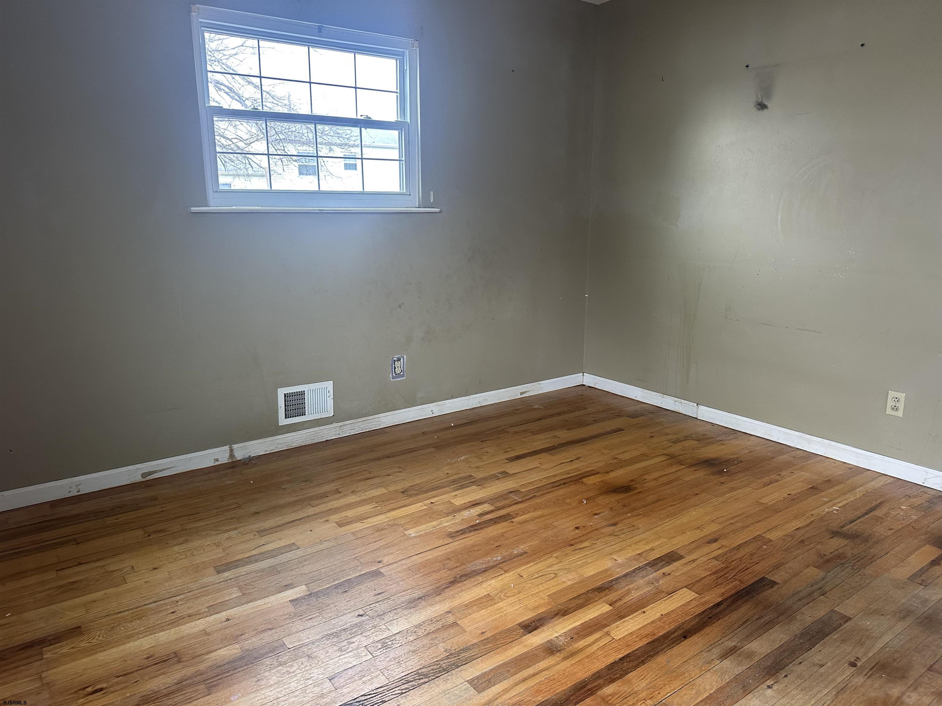 968 Hazelwood Road Toms River, NJ 08753 - Photo 23 of 25 an empty room with wooden floor and windows