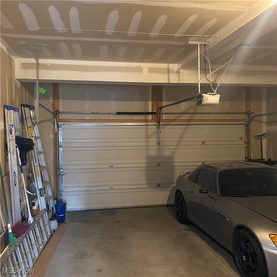 2113 Fowl Road Elyria, OH 44035 - Photo 37 of 39 Garage with tall ceilings featuring a garage door opener, finished walls, electrical