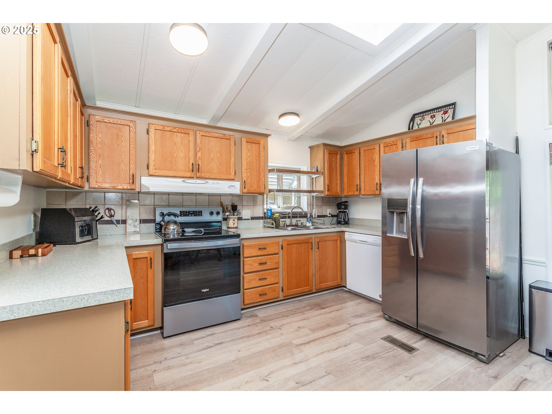 7455 Southeast King Road, Unit 53 Milwaukie, OR 97222 - Photo 8 of 33 a kitchen with stainless steel appliances granite countertop a refrigerator a sink dishwasher a stove with wooden cabinets