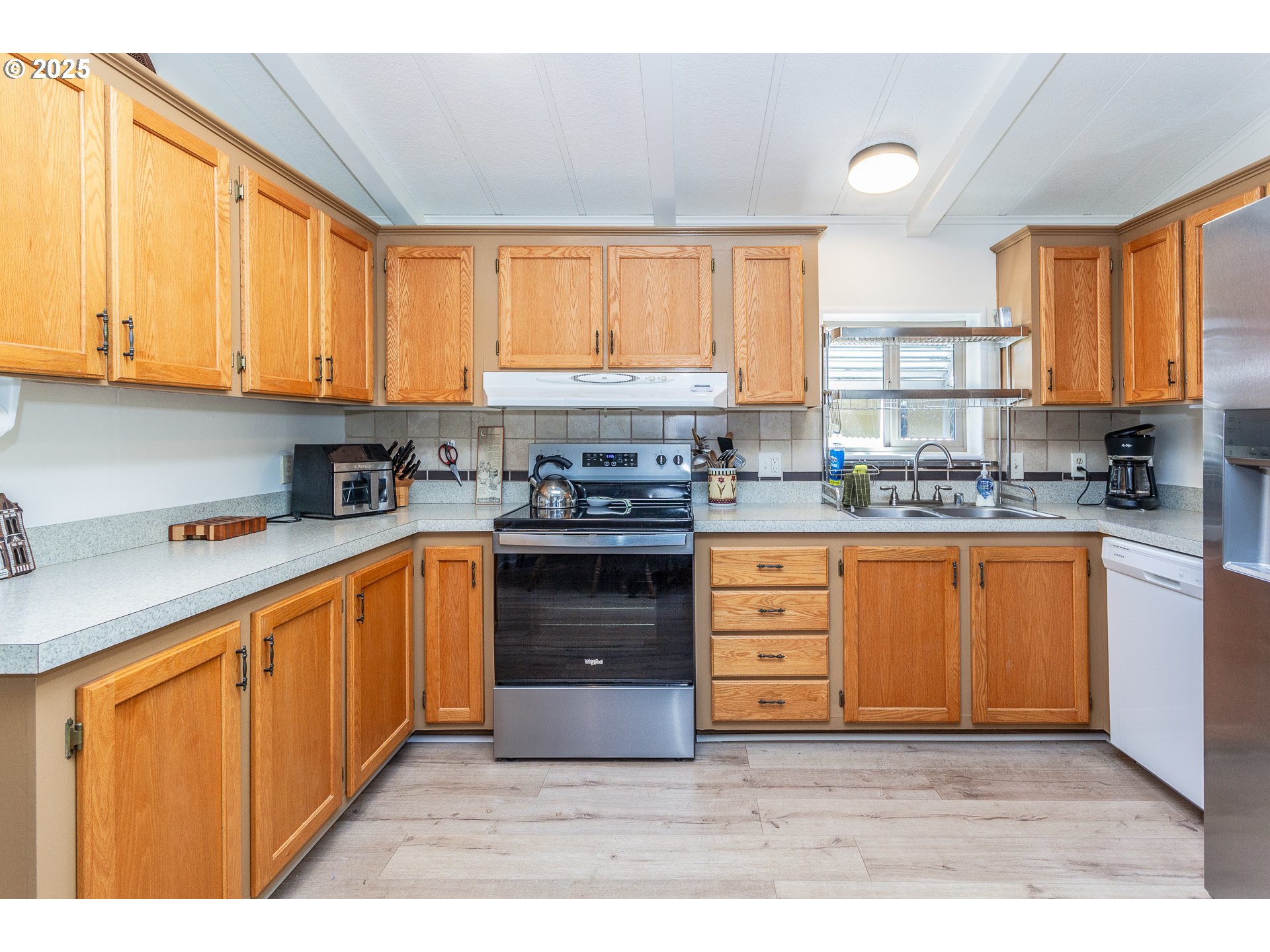 7455 Southeast King Road, Unit 53 Milwaukie, OR 97222 - Photo 9 of 33 a kitchen with stainless steel appliances granite countertop a stove a sink and a refrigerator