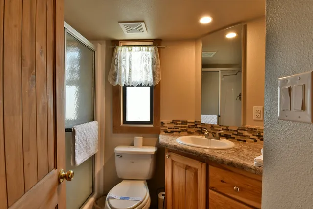 a bathroom with a granite countertop sink toilet and shower