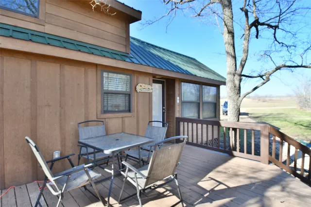 a view of a patio with a table and chairs next to a yard