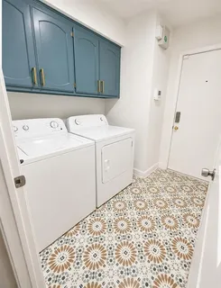 a utility room with cabinets washer and dryer