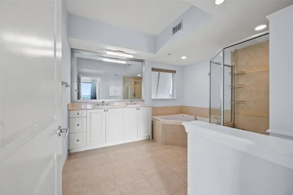 a large bathroom with a large mirror vanity and shower