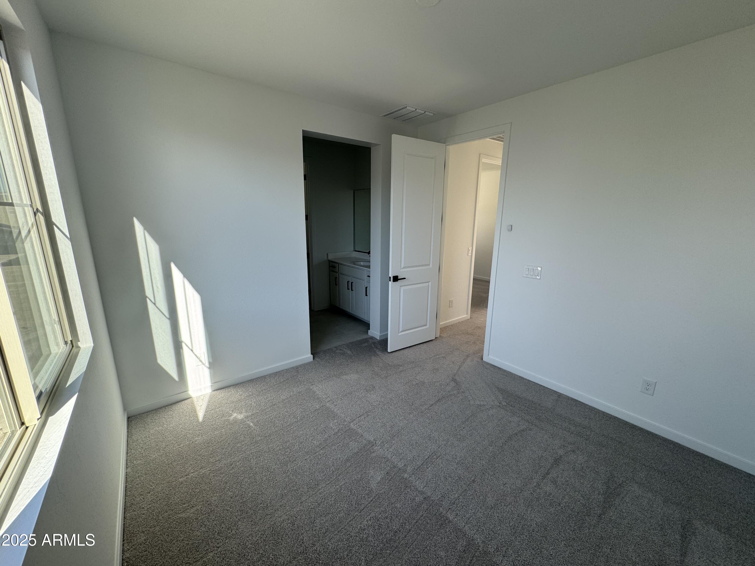 2454 West Maximo Way Phoenix, AZ 85085 - Photo 23 of 27 an empty room with a fireplace and windows