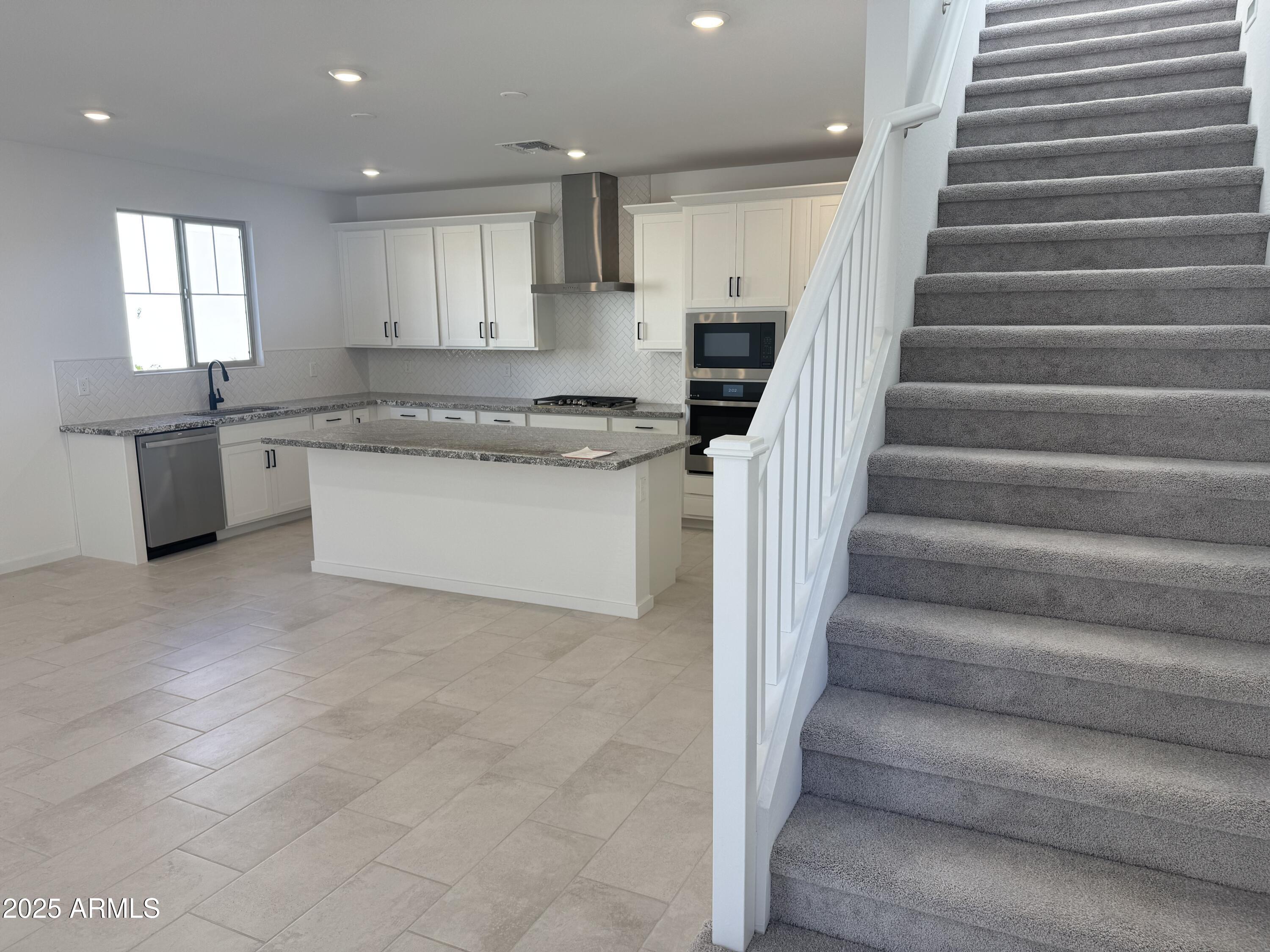 2454 West Maximo Way Phoenix, AZ 85085 - Photo 4 of 27 a kitchen with white cabinets and white appliances