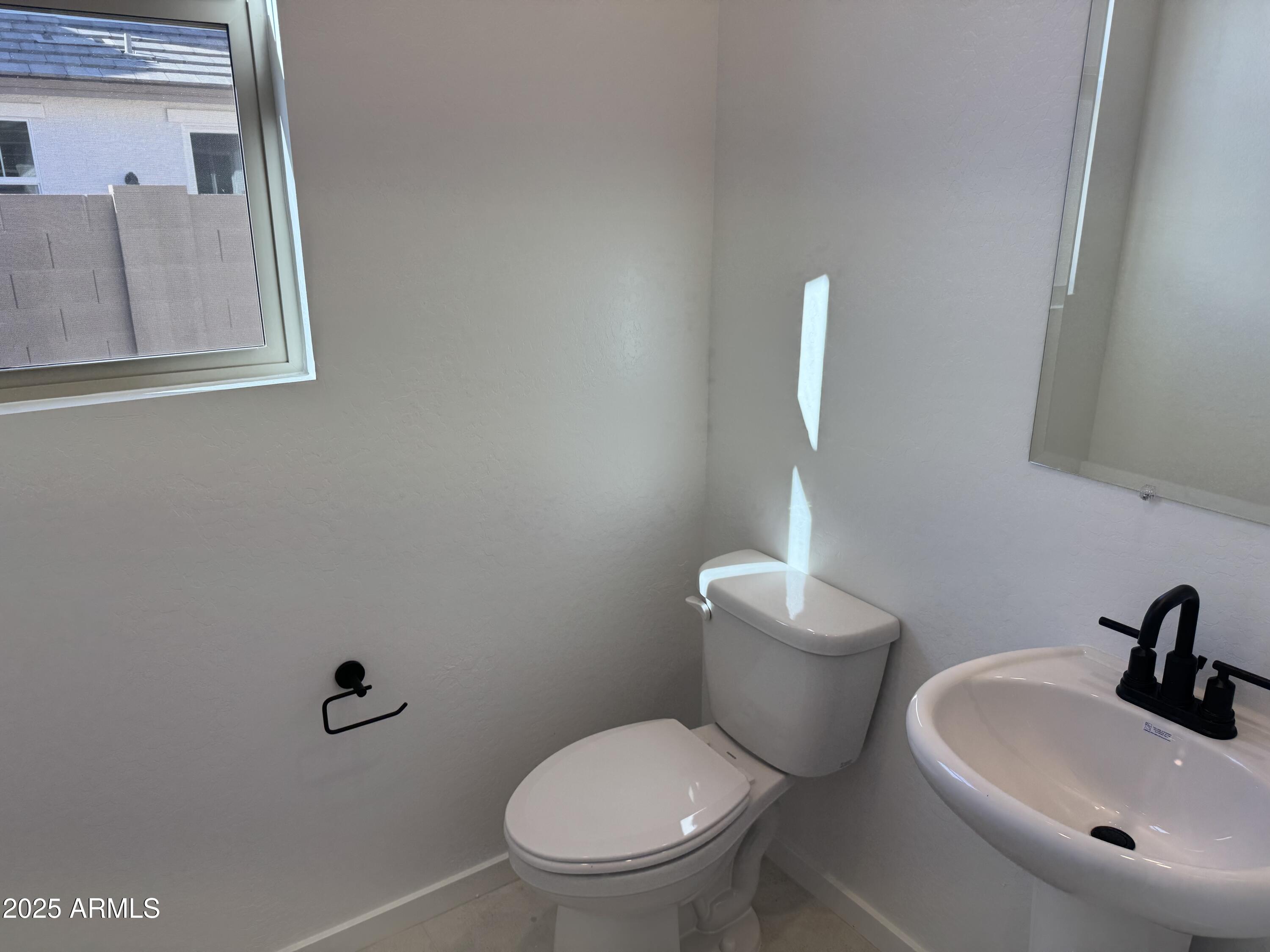 2454 West Maximo Way Phoenix, AZ 85085 - Photo 8 of 27 a white toilet sitting next to a bathroom sink