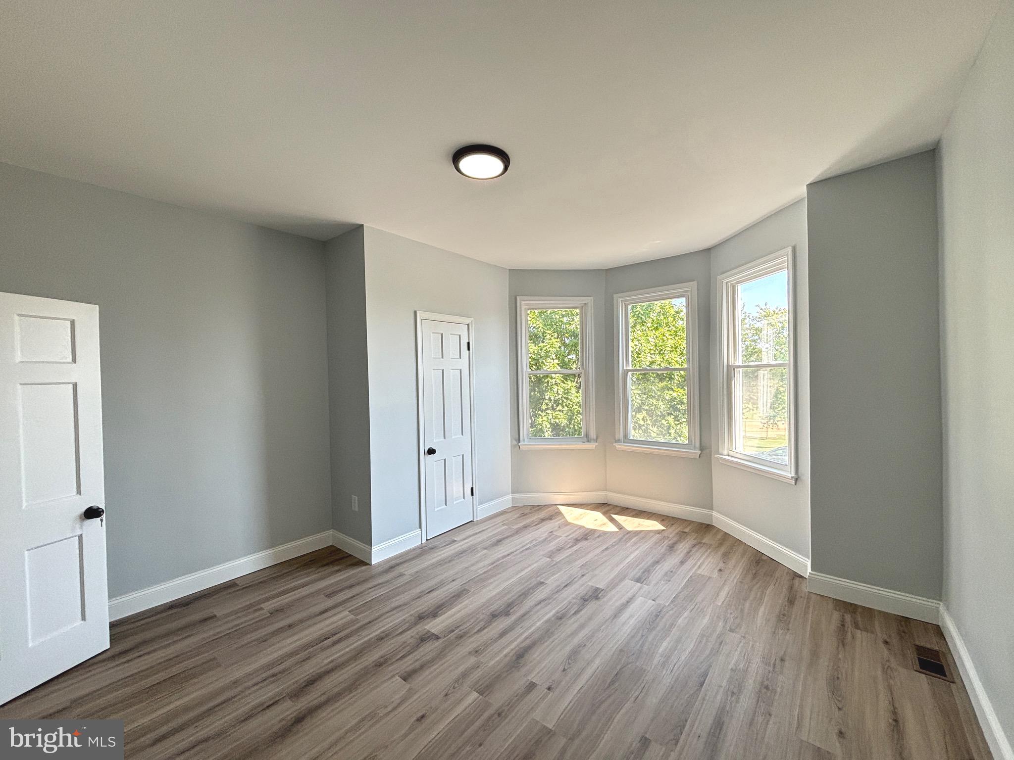 2636 Harford Road Baltimore, MD 21218 - Photo 13 of 18 a view of an empty room with wooden floor and a window