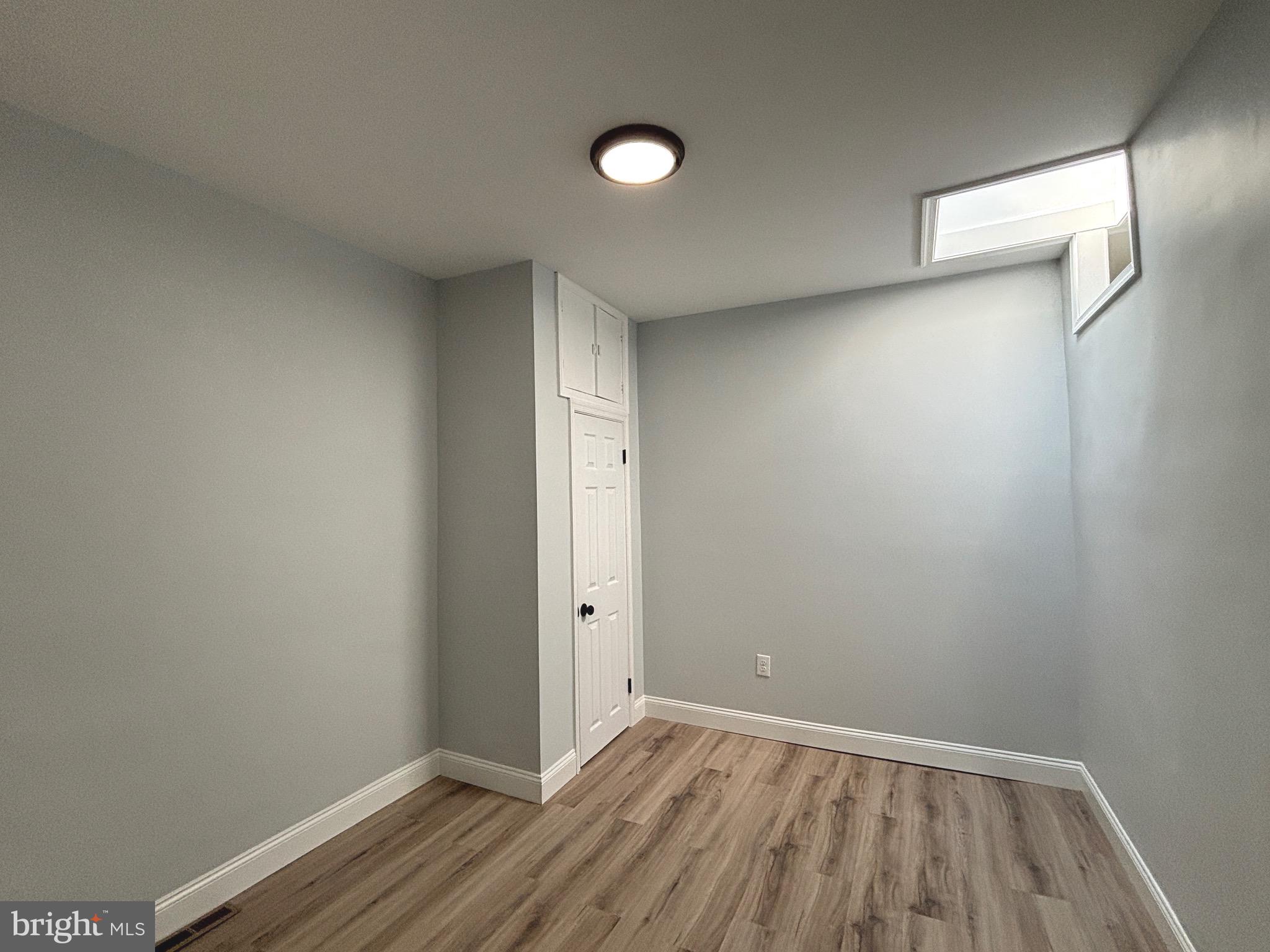2636 Harford Road Baltimore, MD 21218 - Photo 16 of 18 a view of an empty room with wooden floor and a window