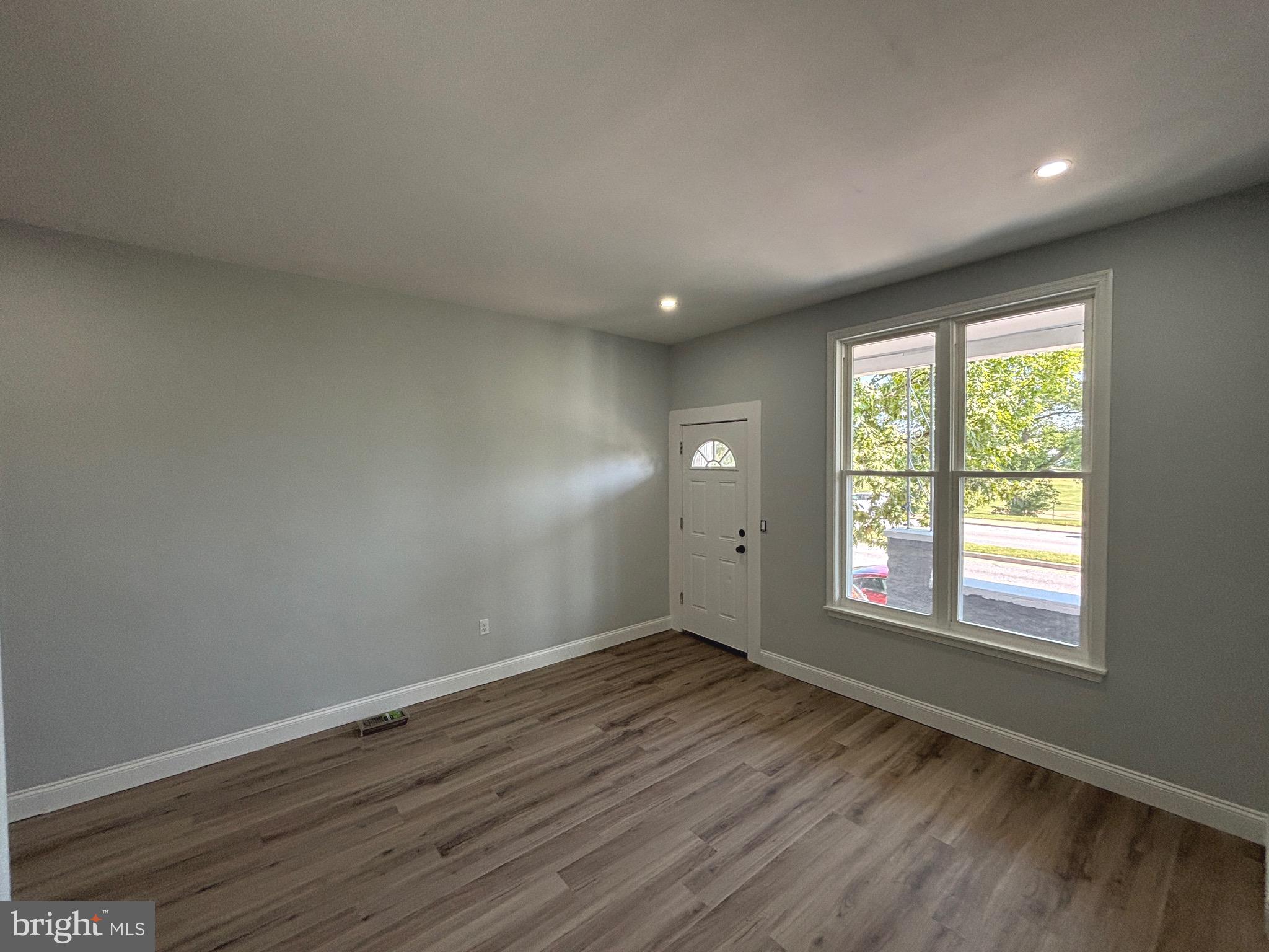 2636 Harford Road Baltimore, MD 21218 - Photo 5 of 18 an empty room with wooden floor and windows