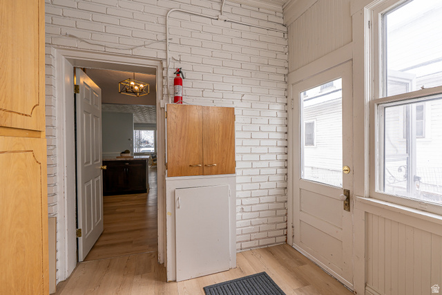 33 North 200 East Logan, UT 84321 - Photo 15 of 54 Doorway to outside with brick wall, wood finished floors, and a chandelier