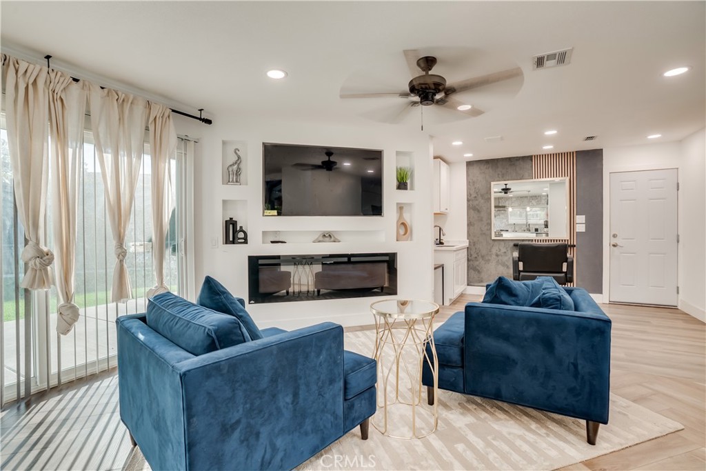 1450 Vía Vallarta Riverside, CA 92506 - Photo 18 of 36 a living room with furniture a flat screen tv and a fireplace