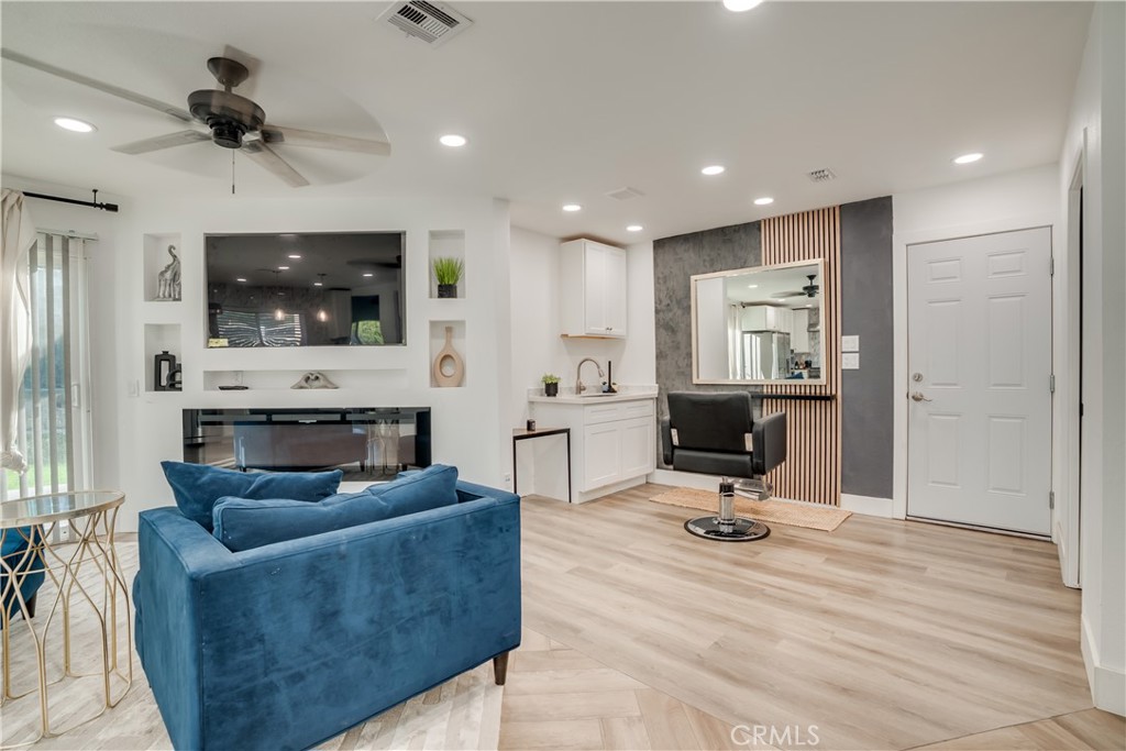 1450 Vía Vallarta Riverside, CA 92506 - Photo 19 of 36 a living room with furniture a flat screen tv and a fireplace