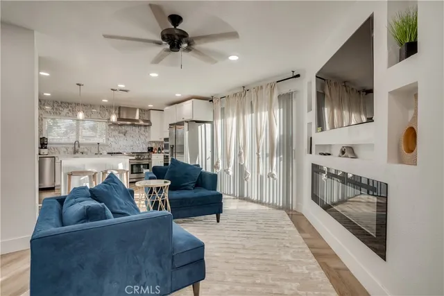 a living room with furniture and a view of kitchen