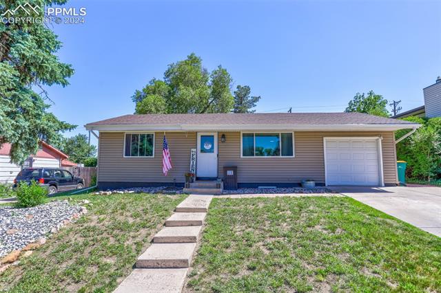 3335 Santa Rosa Street Colorado Springs, CO 80909 - Photo 1 of 21 Ranch-style home featuring a front lawn and a garage