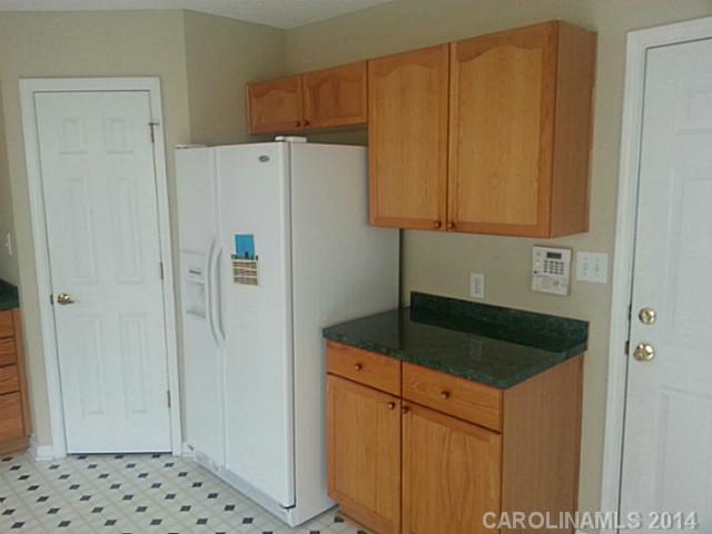 911 Reigate Road Charlotte, NC 28262 - Photo 8 of 14 a kitchen with a refrigerator and cabinets