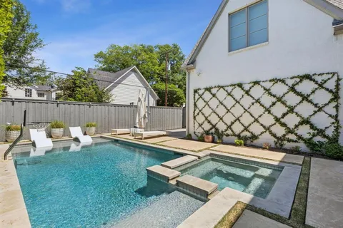 a view of a backyard with swimming pool and sitting area