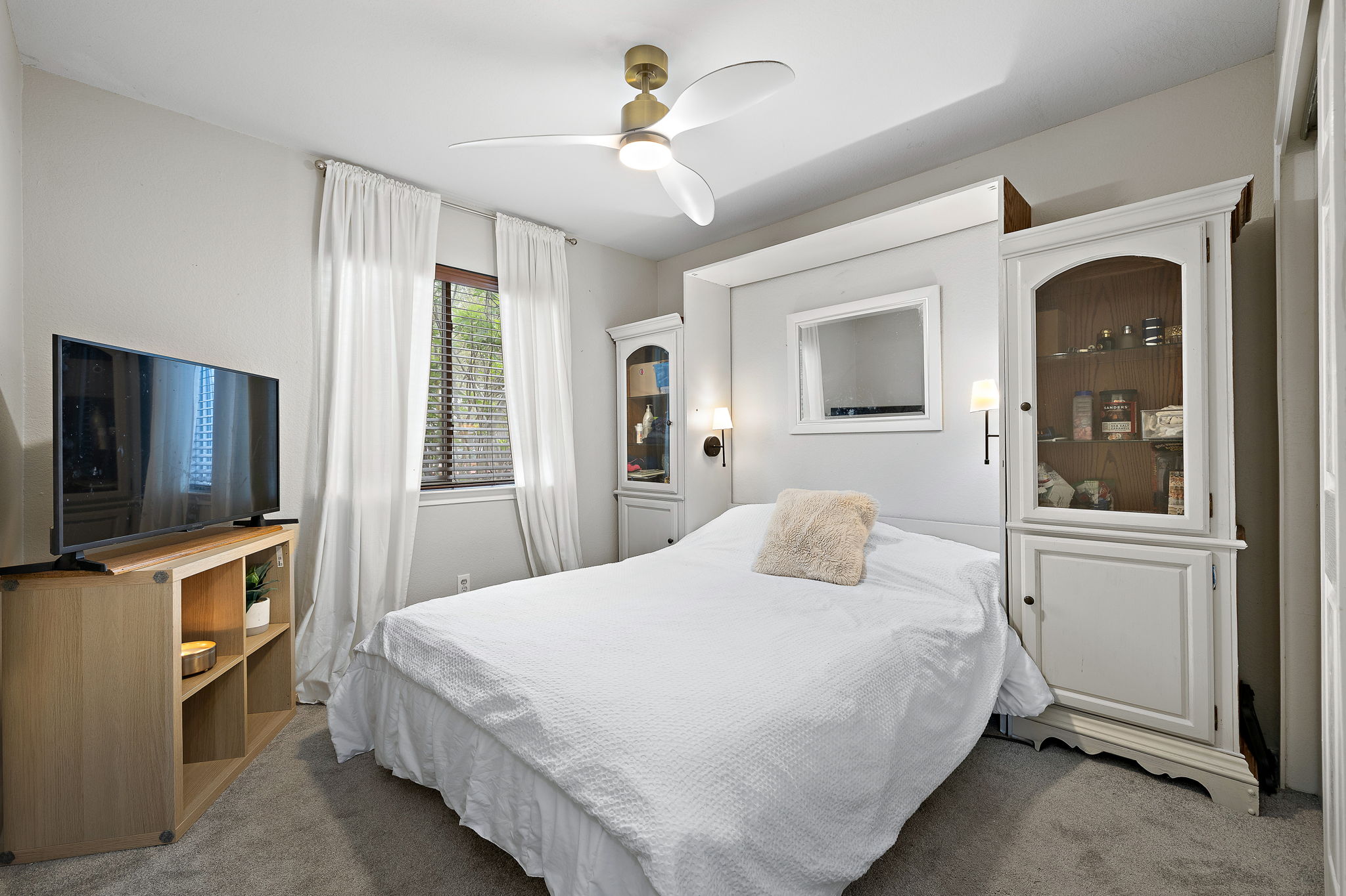 107 Easy Street Hutto, TX 78634 - Photo 14 of 34 a bedroom with a bed and a flat tv screen on dresser