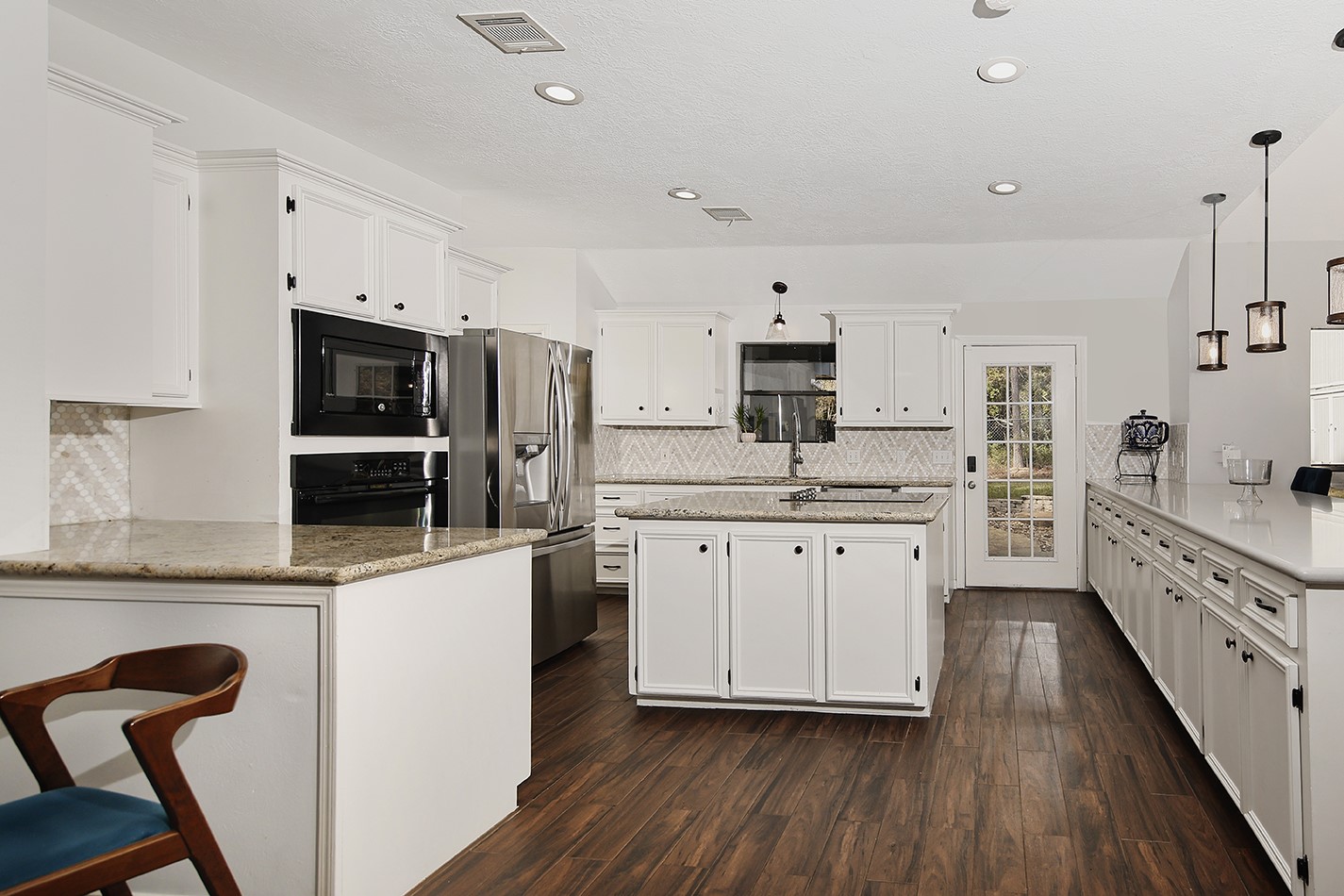 44 Lake Forest Circle Conroe, TX 77384 - Photo 7 of 45 a kitchen with white cabinets and stainless steel appliances