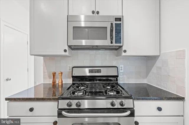 a stove top oven sitting inside of a kitchen