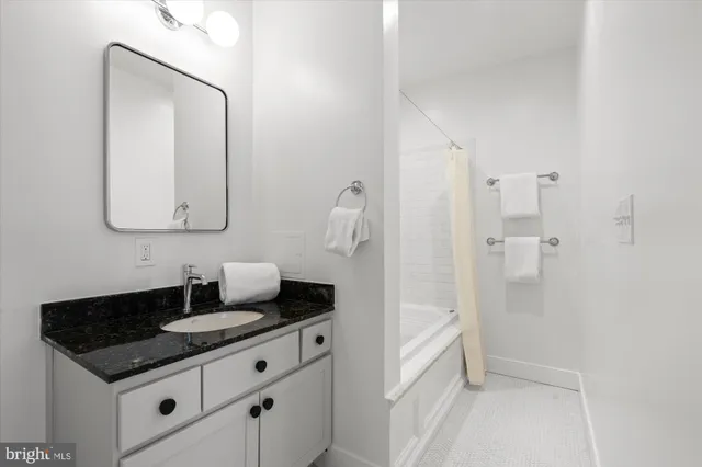 a bathroom with a granite countertop sink and a mirror