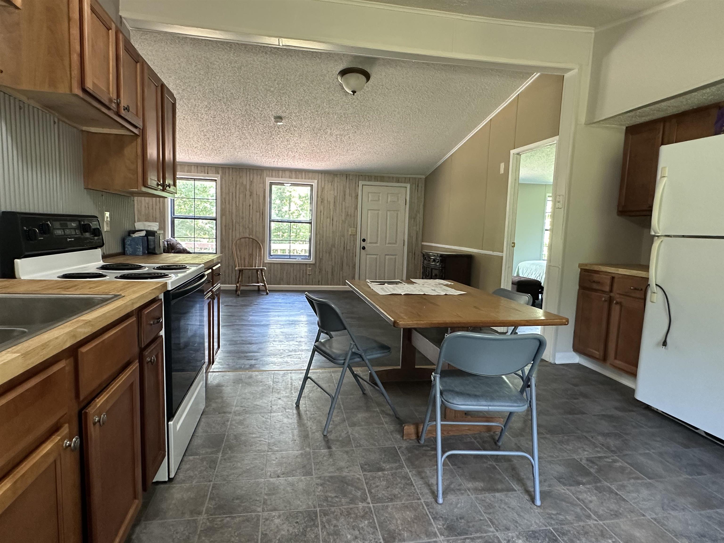 6264 45th Highway South Ramer, TN 38367 - Photo 28 of 30 a kitchen with a table chairs sink and refrigerator