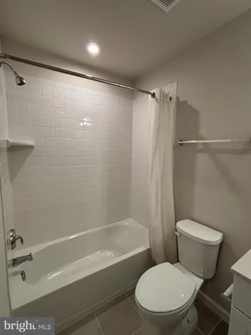 a white toilet sitting next to a bath tub and a shower