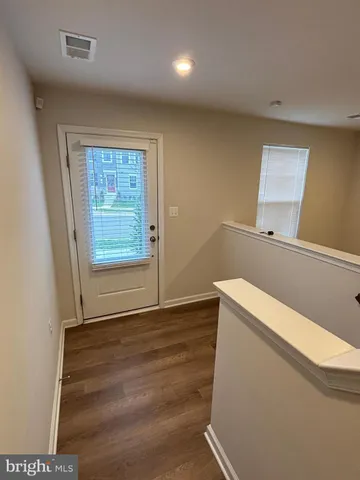 a view of empty room with window and wooden floor