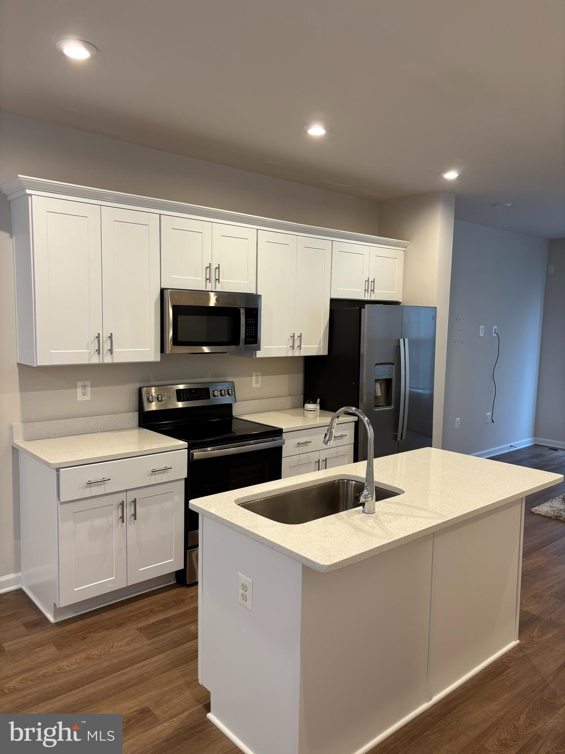 24 Anthem Street Ranson, WV 25438 - Photo 4 of 23 a kitchen with granite countertop a refrigerator a stove a sink and white cabinets with wooden floor