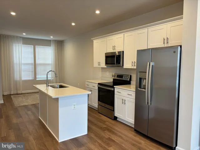 a kitchen with a sink a refrigerator and a stove top oven