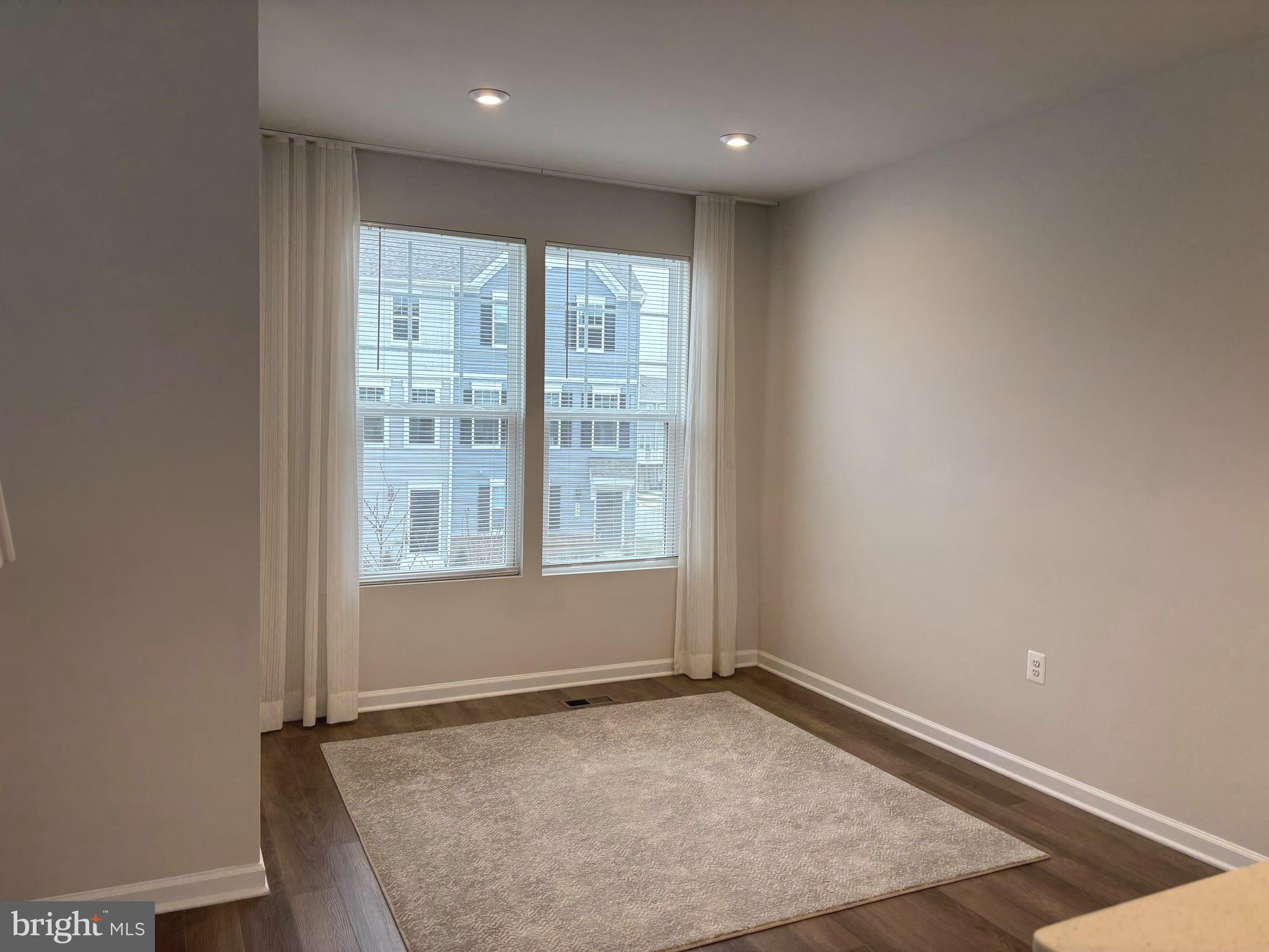 24 Anthem Street Ranson, WV 25438 - Photo 8 of 23 an empty room with wooden floor and windows