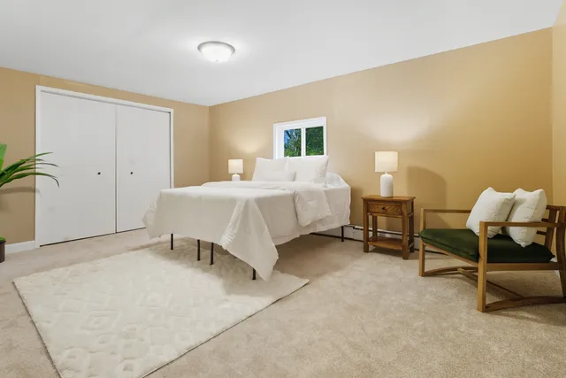 a spacious bedroom with a bed and a chair