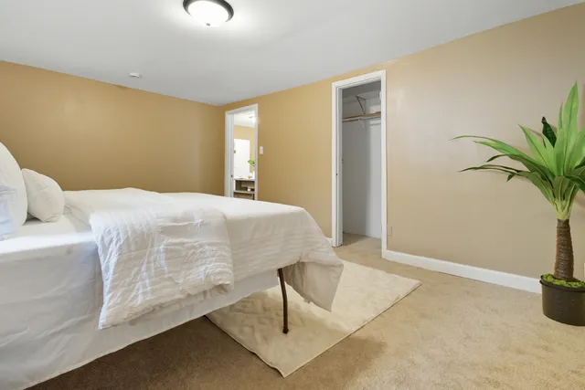 a bedroom with a bed and potted plant