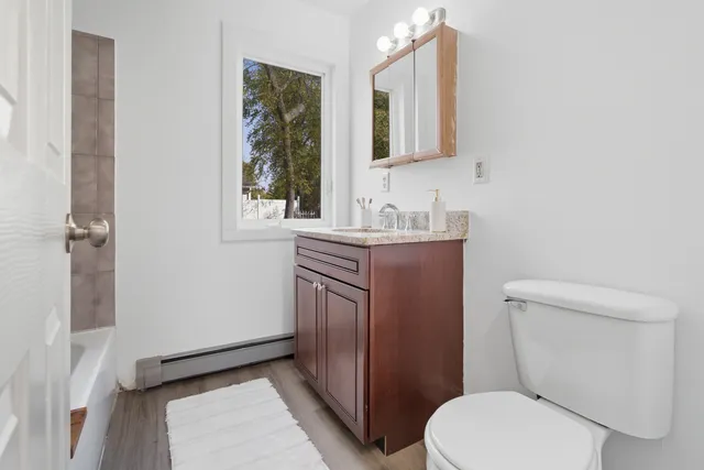 a bathroom with a toilet a sink and mirror